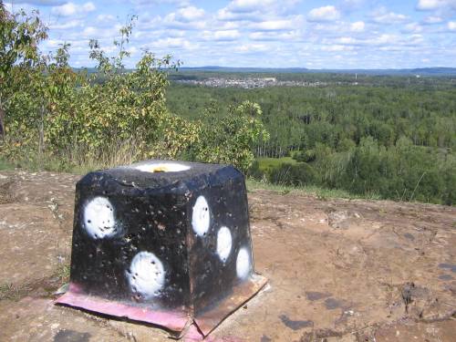 [Cube decorated to look like a die at a scenic bluff overlooking Thunder Bay]